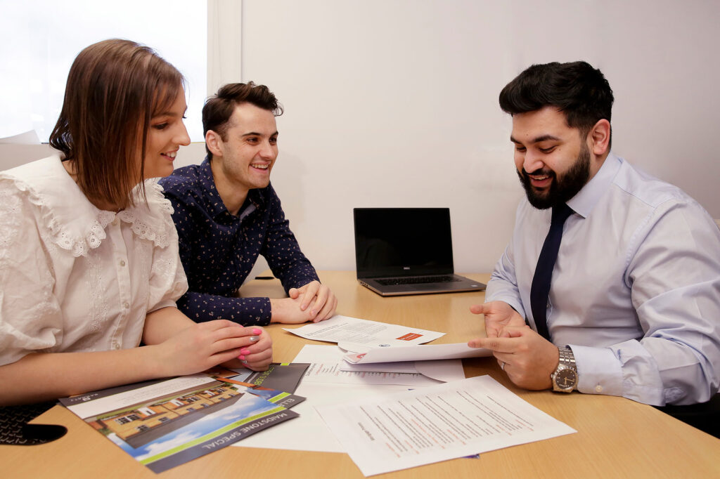 Young couple signing contract with a mortgage advisor from Dupree and Co