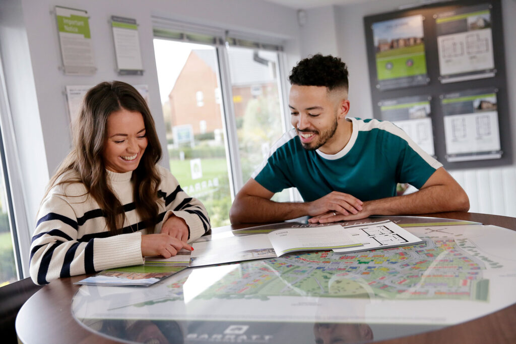 Young couple looking at plans for their new build home