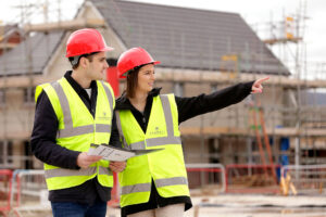 Young couple looking at their new build home on the building site