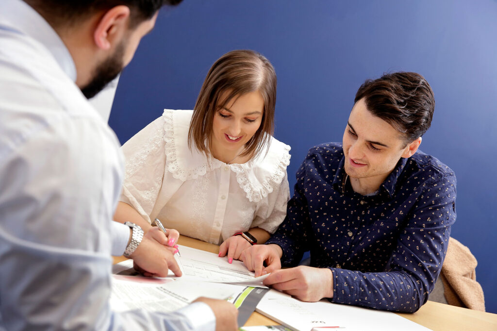 Young couple signing contract with a mortgage advisor from Dupree and Co