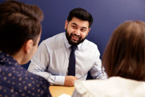 Young couple signing contract with a mortgage advisor from Dupree and Co